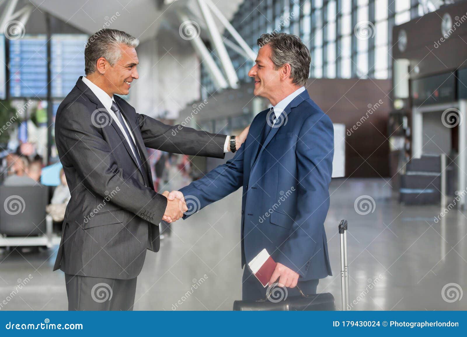 在机场与商业伙伴握手的成熟商人库存照片 图片包括有行程 到达 护照 生意人 信号交换 会议