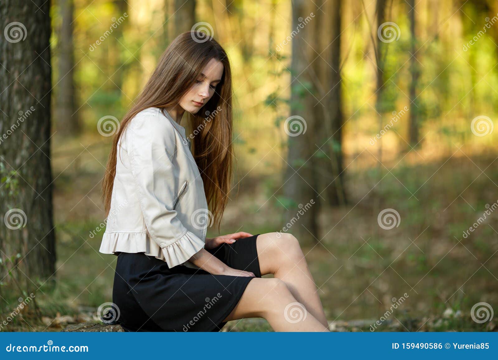 夕阳下 森林里一个年轻漂亮白人少女的画像 头发长长 衣着休闲库存照片 图片包括有