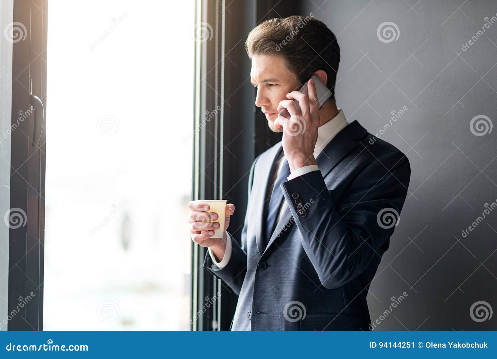 Разговор через часы. Задумчивый человек со смартфоном. Мужчина говорит по телефону. Мужчина с телефоном у окна. Мужчина возле окна.