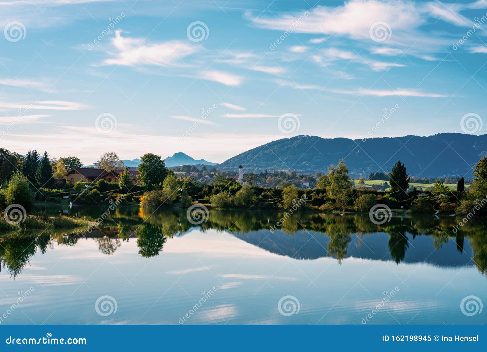 巴伐利亚州科尼斯多夫的村庄和教堂 前景是比比湖 背景是山库存图片 图片包括有田园诗 照亮