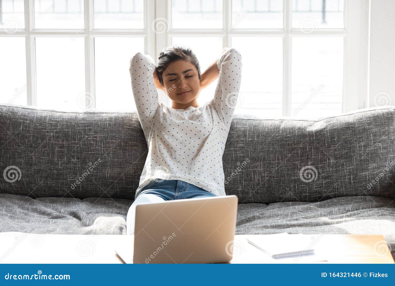 平静的年轻印度女性在工作日后舒适的沙发上放松库存照片 图片包括有精神 头脑 女实业家 作白日梦