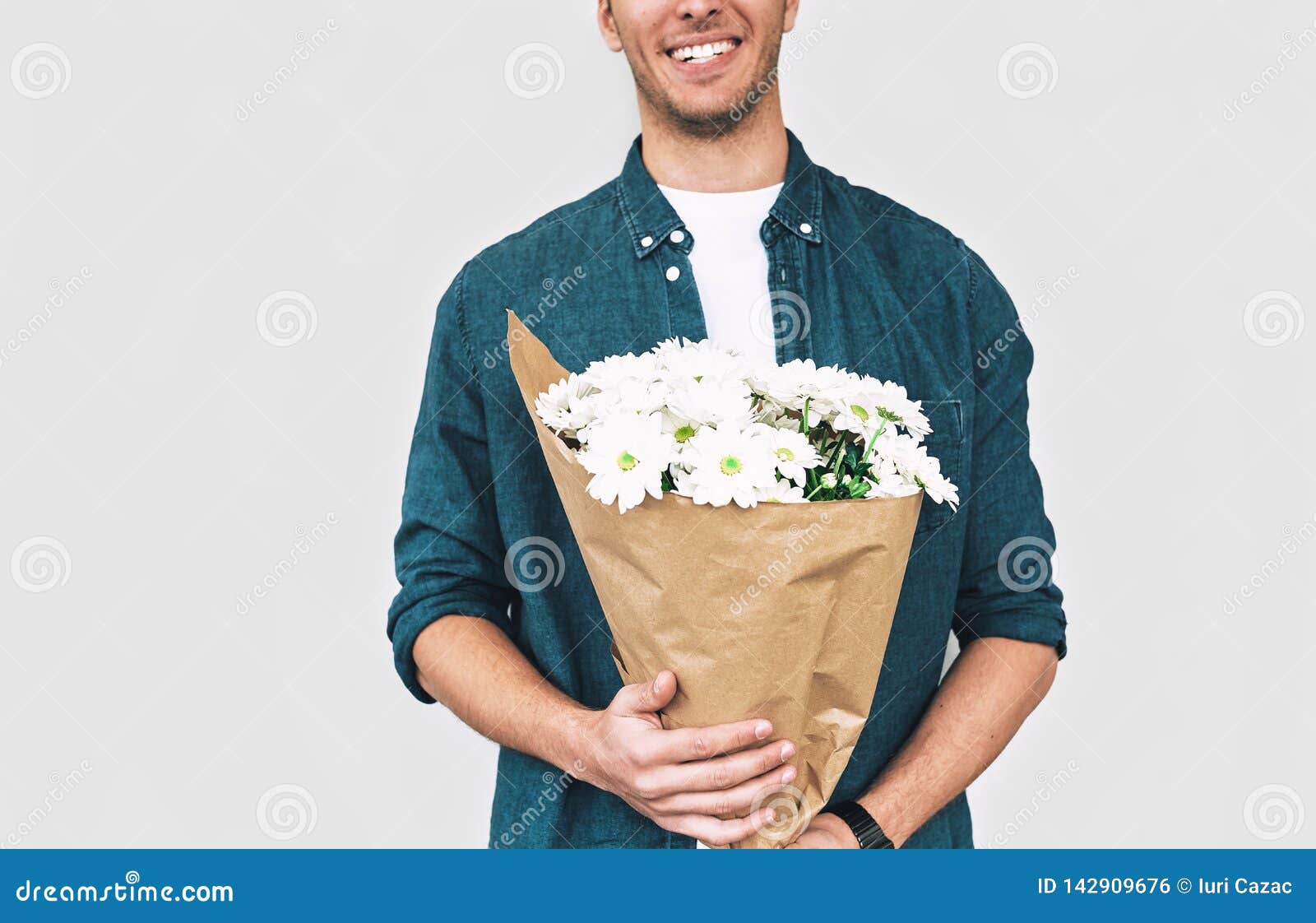 微笑和交付白花的花束年轻愉快的人英俊的男性播种的射击与一束花的库存照片 图片包括有英俊的男性播种的射击与一束花的 微笑和交付白花的花束年轻愉快的人