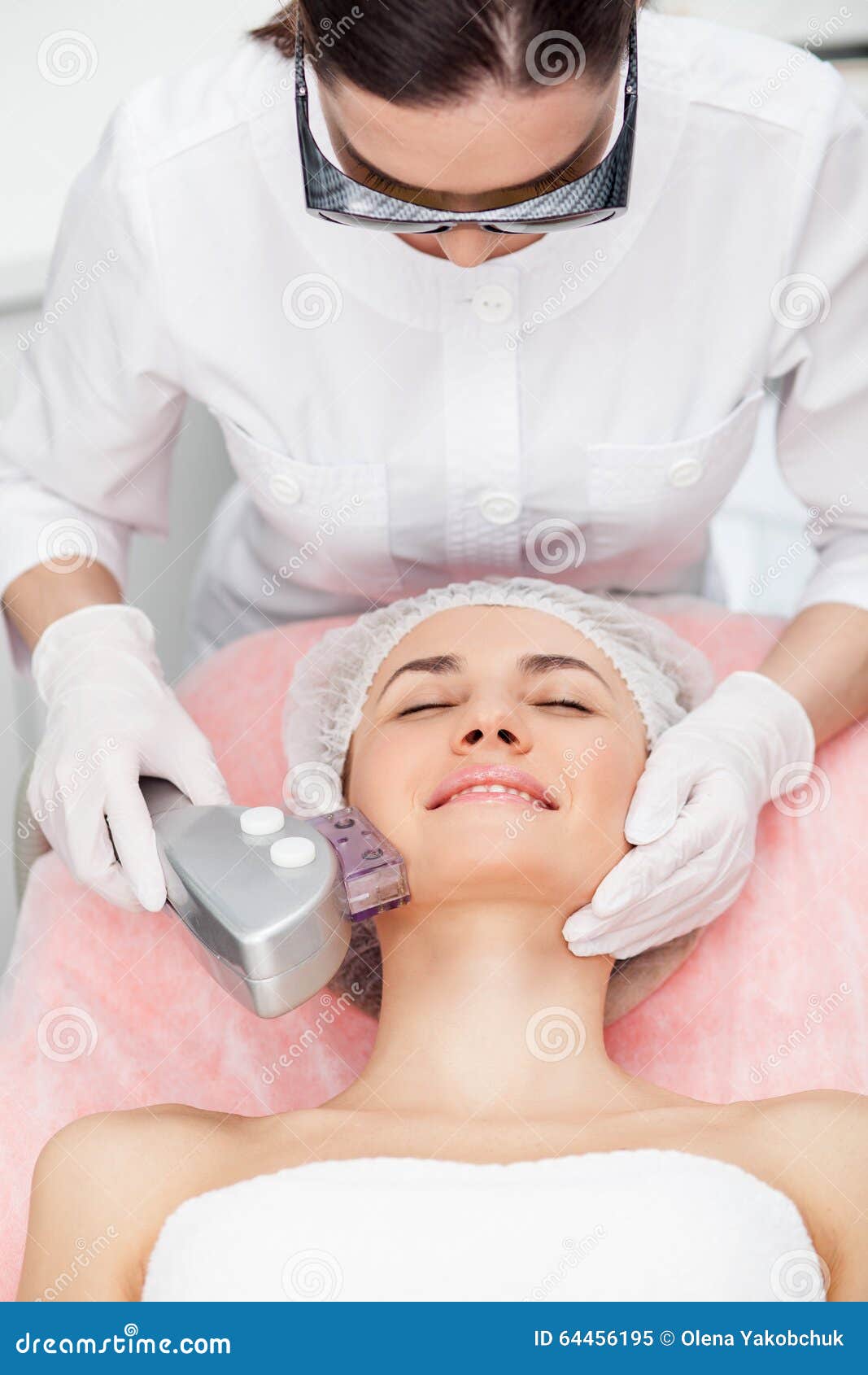 快乐的女性美容师与患者一起使用库存图片 图片包括有发红光的 产品 人类学 女性 部分 纵容