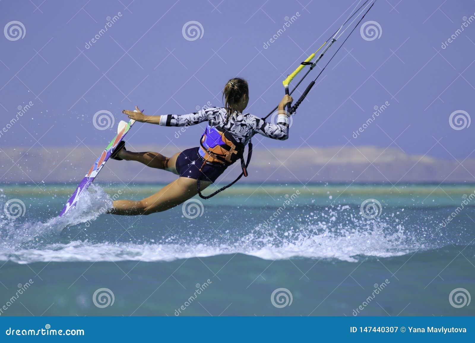 性感的泳装的风筝冲浪的女孩有在天空的风筝的在船上在蓝色与水飞溅的海乘坐的波浪消遣活动库存图片 图片