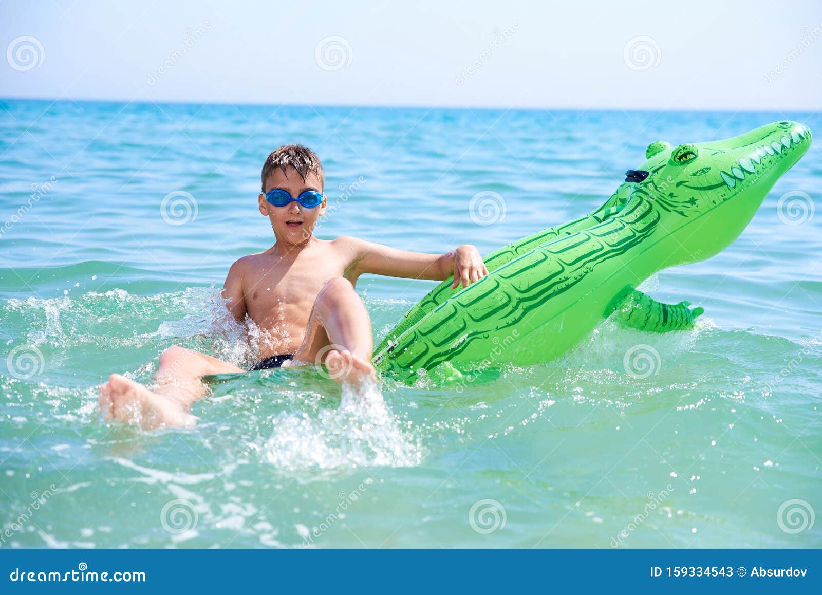 戴着水泳的青少年男孩在充气玩具鳄鱼身上游泳库存图片 图片包括有戴着水泳的青少年男孩在充气玩具鳄鱼身上游泳
