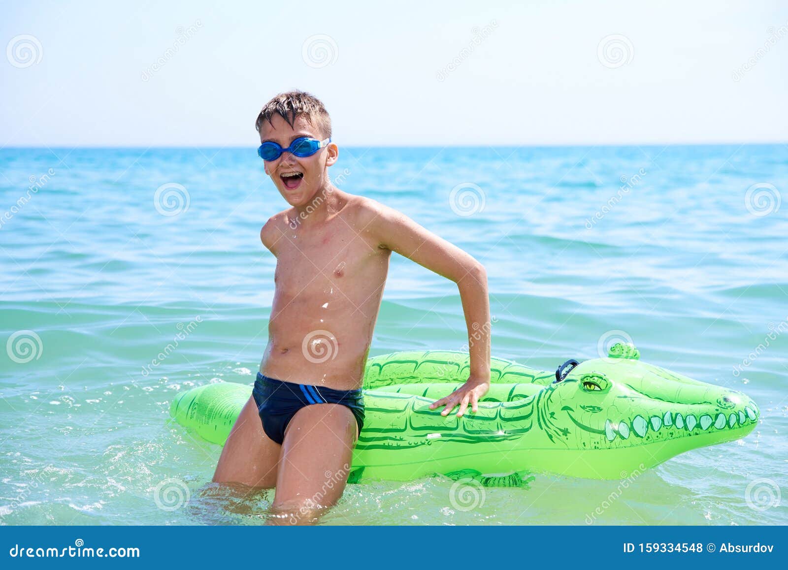 戴着水泳的青少年男孩在充气玩具鳄鱼身上游泳库存照片 图片包括有戴着水泳的青少年男孩在充气玩具鳄鱼身上游泳