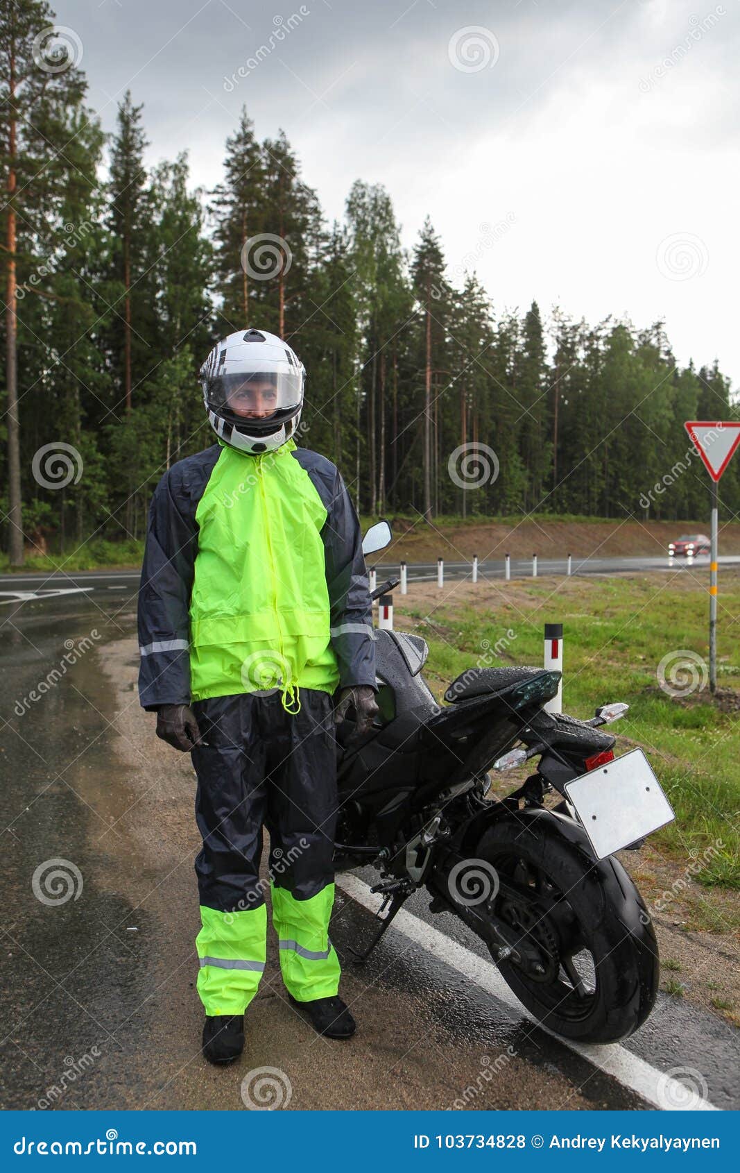 摩托车骑士佩带黑和黄色雨衣和身分与摩托车的旅客画象在高速公路在雨天气库存照片 图片包括有涂柏油的 驱动器