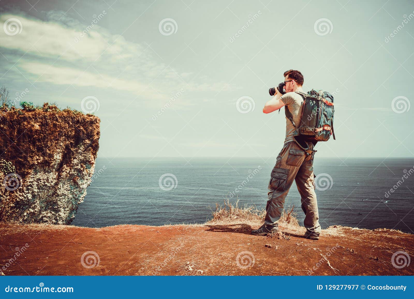 旅客有照相机的人背包徒步旅行者在自然背景在手中做照片热带海滩库存图片 图片包括有旅客有照相机的人背包徒步旅行者在自然背景在手中做照片热带海滩