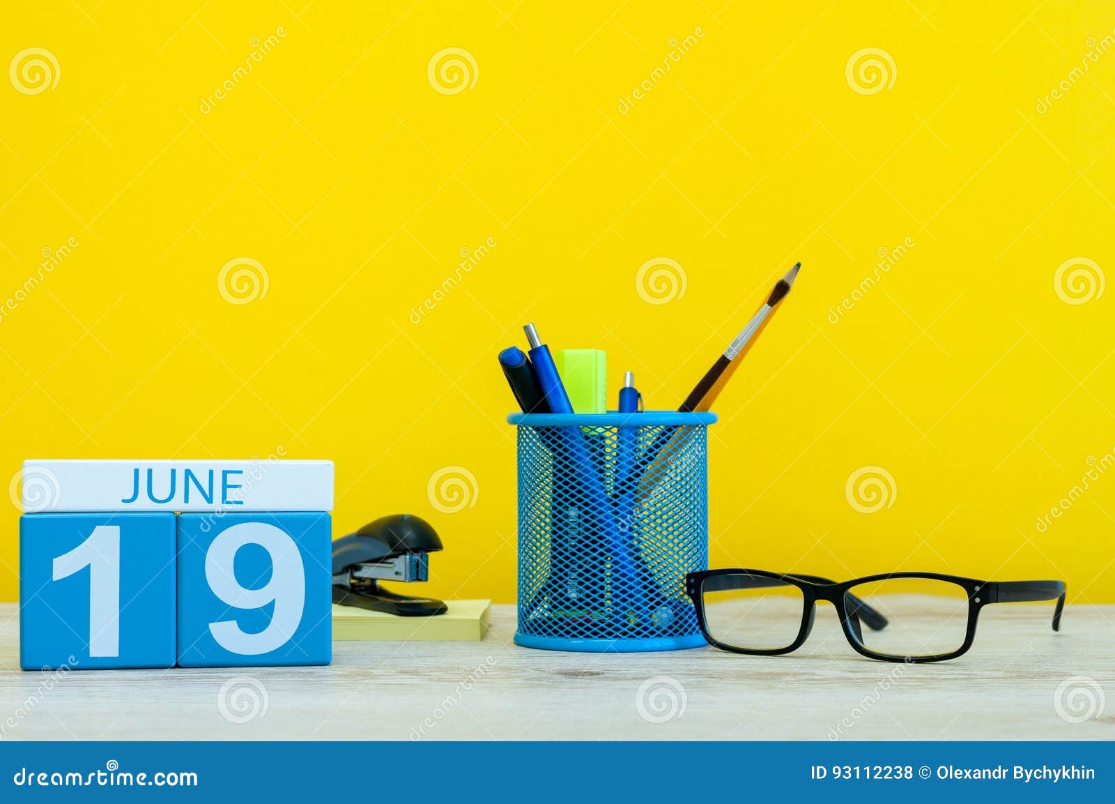 6月19日天19月 在黄色背景的日历与办公室suplies 夏时在工作库存照片 图片包括有