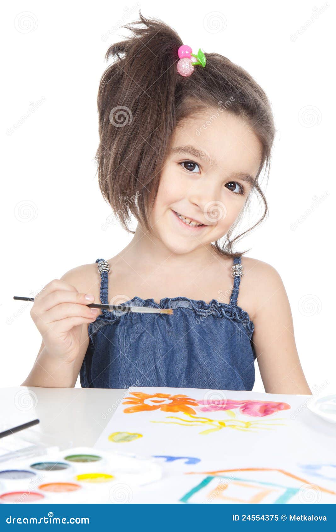 Little brunette. Маленькая девочка рисует за столиком фото.