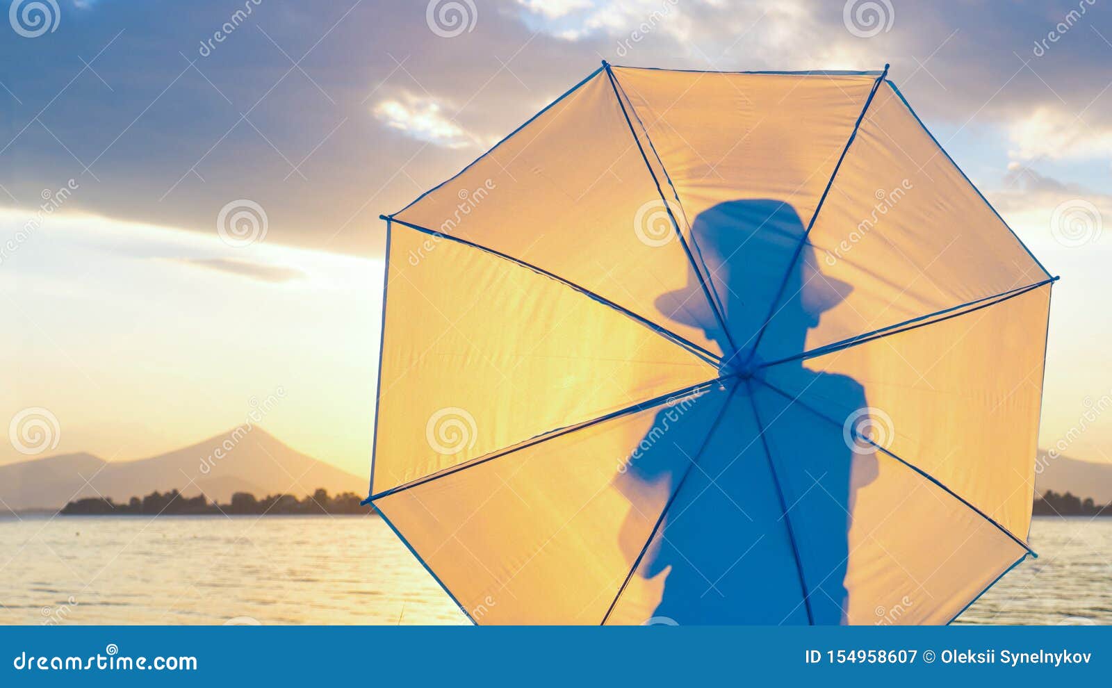 照片写真背景时髦的行家 帽子的小男孩有在海滨的伞的人后面景色的剪影库存图片 图片包括有凝视 日落