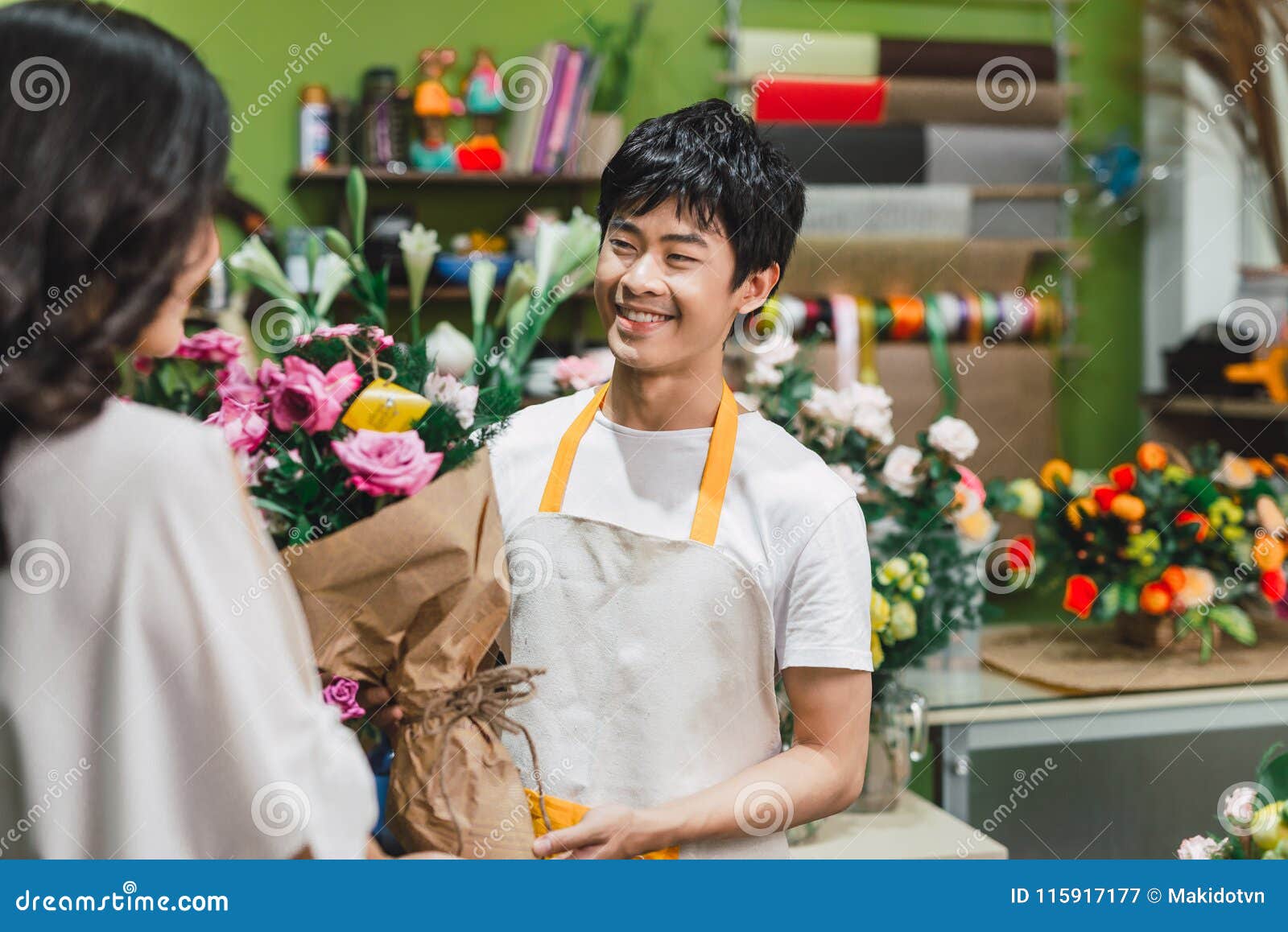 男性在柜台的卖花人提供的花在花店库存图片 图片包括有男性在柜台的卖花人提供的花在花店