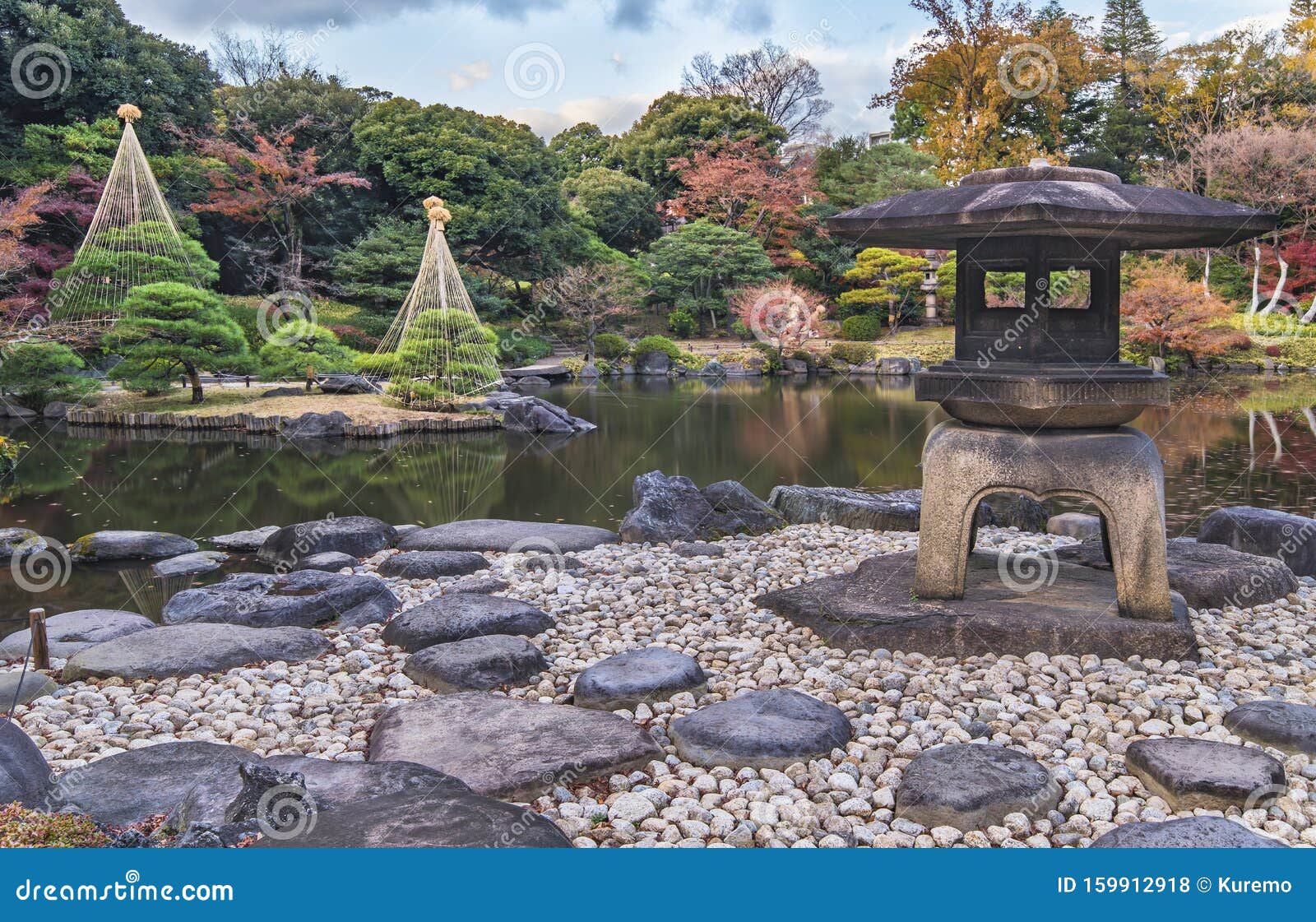 秋日东京都公园古川日式花园的由基木石灯库存照片 图片包括有人们 天空 日本 拱道 公园