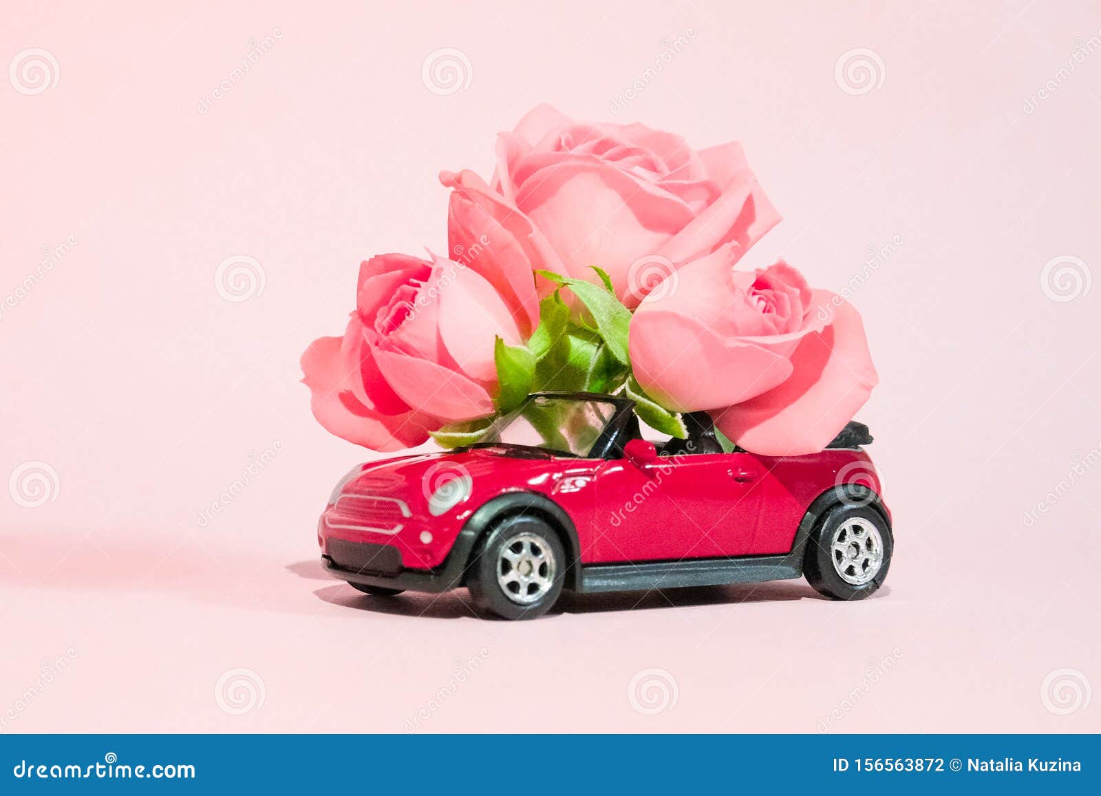 粉色背景中送来一束粉红玫瑰花的红色玩具车2月14日贺卡 情人节花库存照片 图片包括有命令 编排者