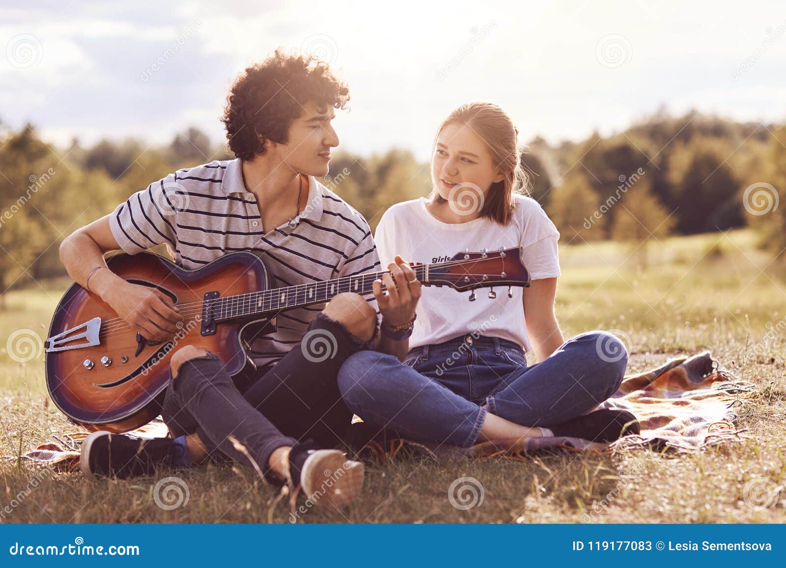 美丽的女性看充满爱 并且在弹吉他并且唱浪漫歌曲给恋人的她的男朋友的幸福 有unforgett 库存图片 图片包括有野餐 友谊