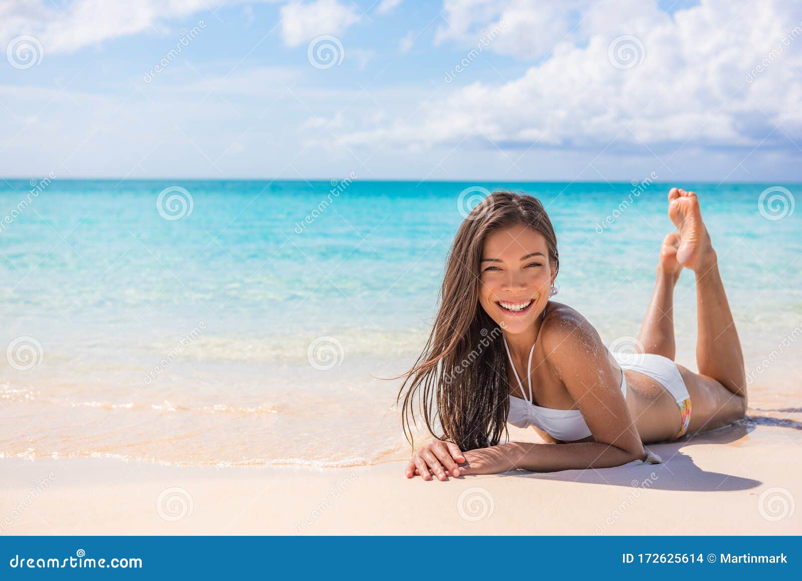 蓝海背景下，在天堂海滩热带旅行的白色沙滩上享受日光浴的亚洲比基尼  image