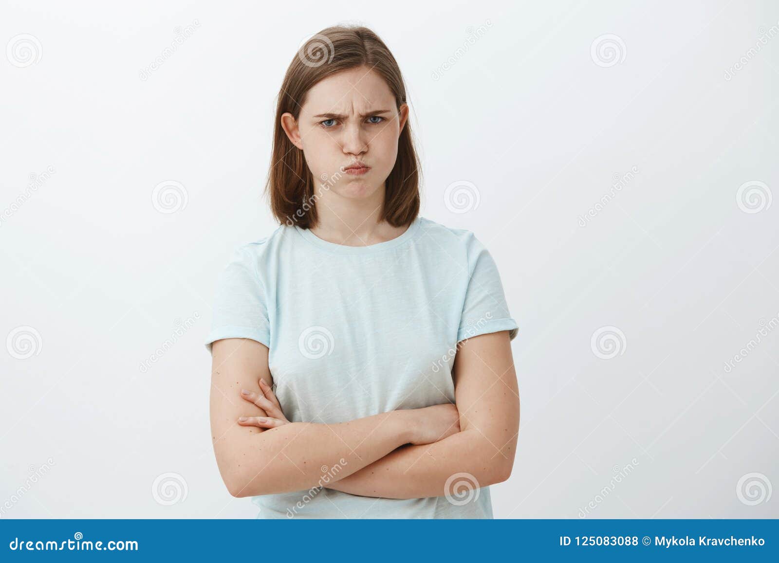 逗人喜爱的疯狂或被触犯的女性演播室射击有拍动的耳朵生气的和皱眉的横穿的在站立的胸口武装库存照片 逗人喜爱的疯狂或被触犯的女性演播室射击有拍动的耳朵生气的和皱眉的横穿的在站立的胸口武装库存照片