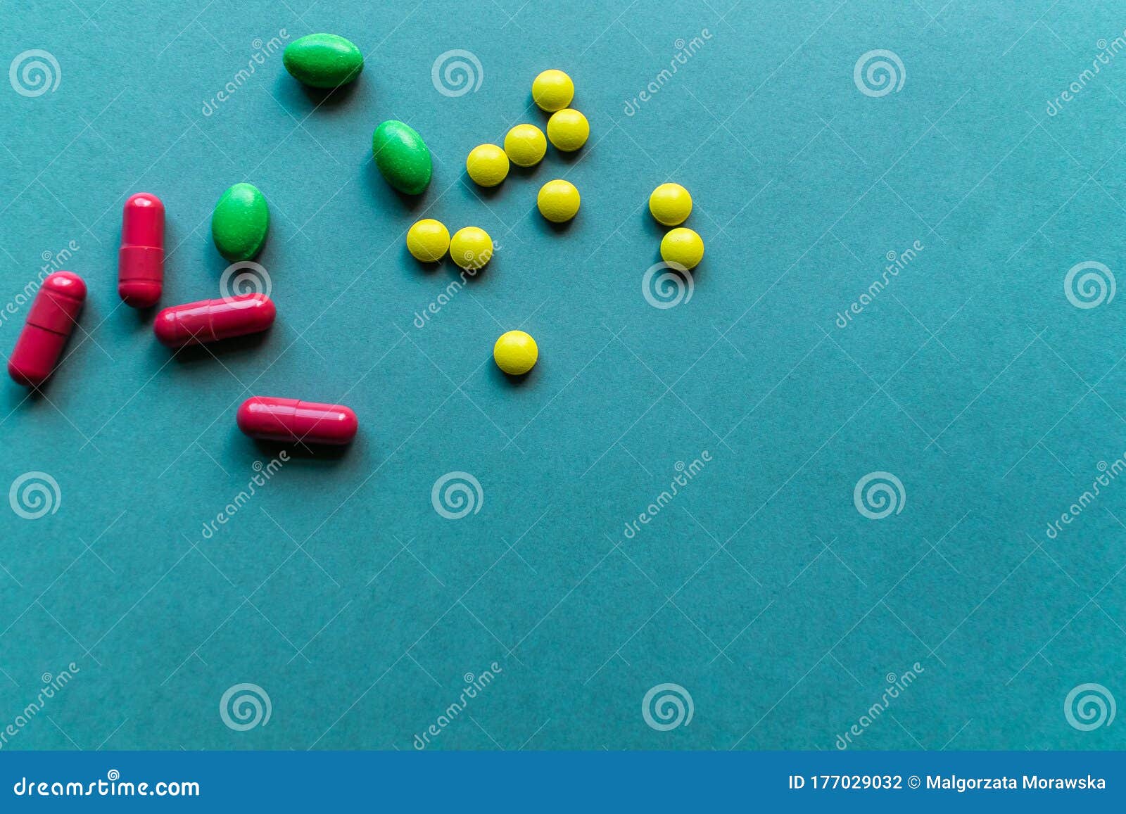 青蓝色背景上的片剂和小胞联 照片左上角的黄色 绿色和橙色药丸 还有维生素库存照片 图片包括有医院 医学