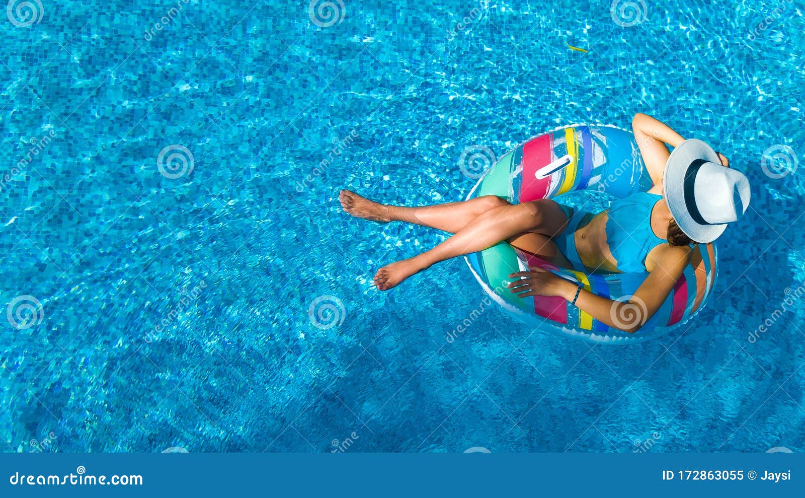 顶着帽子的美女 在泳池的天空中俯瞰 年轻女人在充气环圈上放松和游泳库存图片 图片包括有