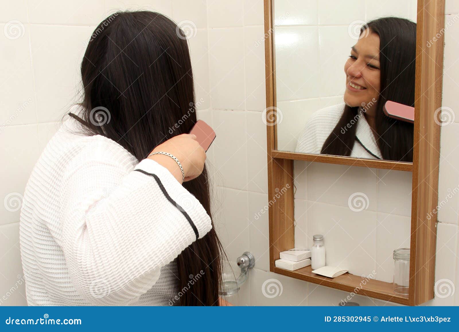 40 Year Old Latina Woman Cares And Brushes Hair In The Bathroom In A