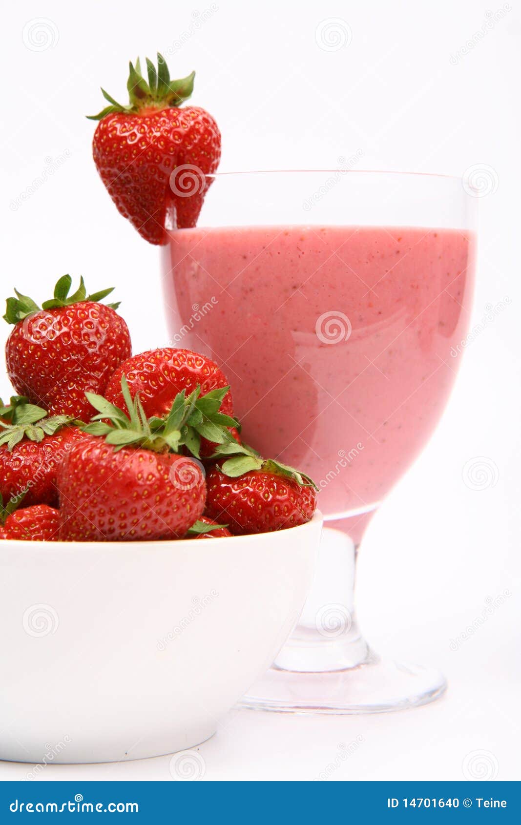 Aardbeien en een aardbeischok. Aardbeien in een kom en een aardbeischok in een glas dat met een aardbei op witte achtergrond wordt verfraaid