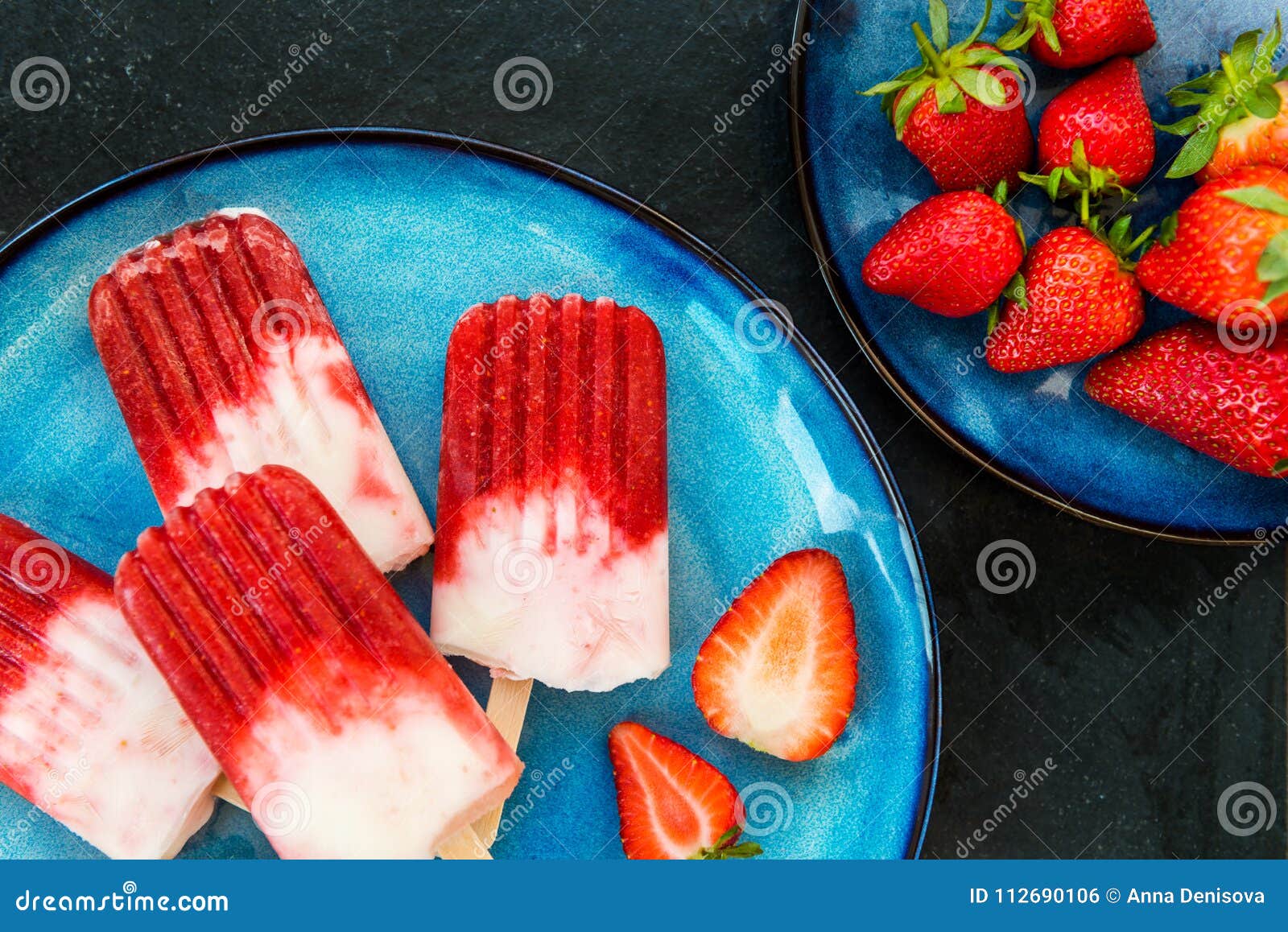 Aardbeiijslolly met Aardbeisap. De eigengemaakte Ijslolly van de Veganistaardbei met Aardbeisap en Kokosmelk op donkere marmeren achtergrond Het concept van het de zomervoedsel Hoogste mening