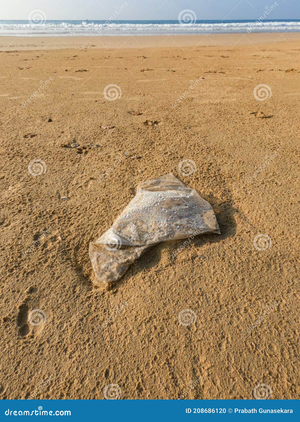 Abandoned Plastic Polythene Bag on the Beach. Stock Photo Image of