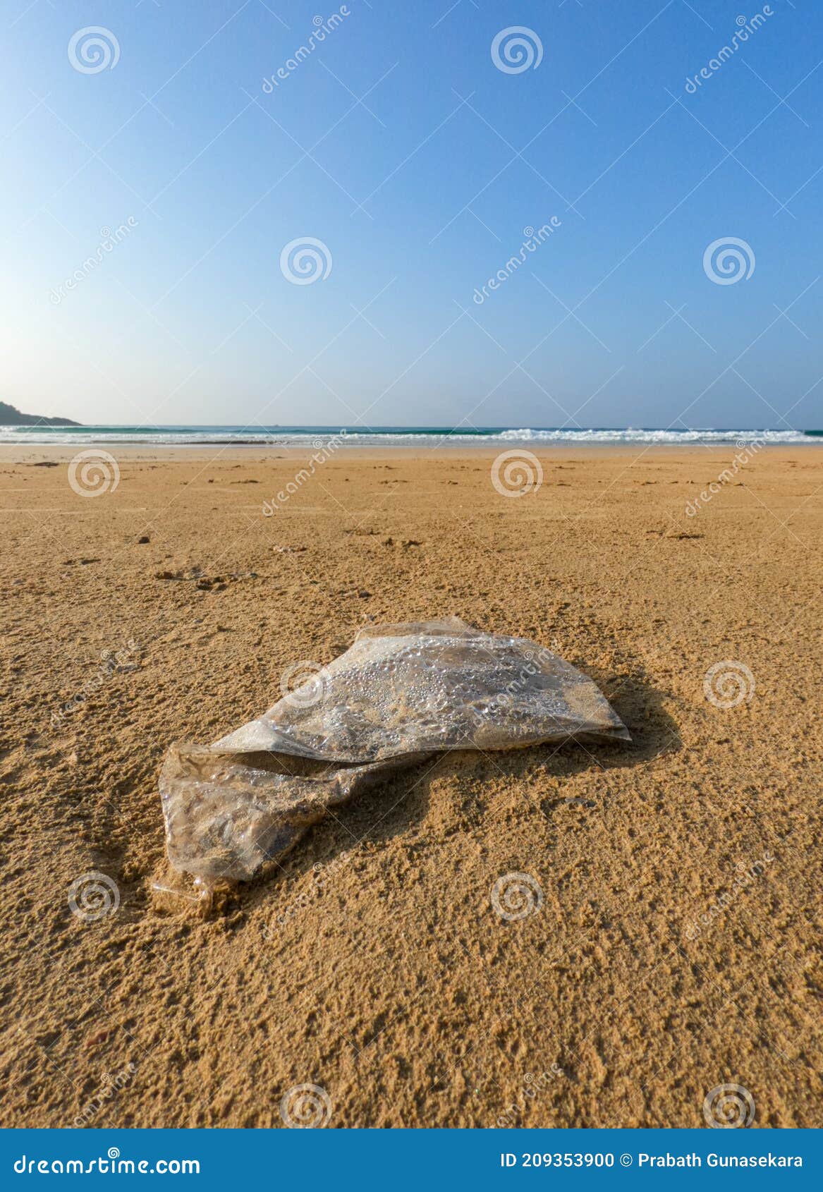 Abandoned Plastic Polythene Bag on the Beach. Stock Photo Image of