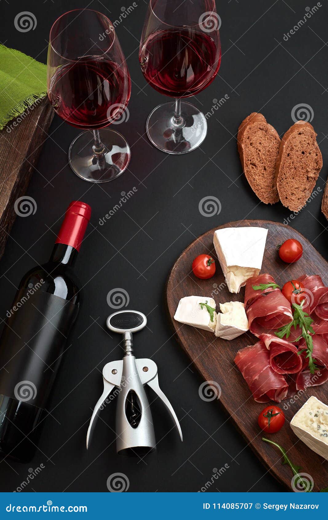 above overhead view flat lay still life of assortment various cheese and delicatessen with traditional bread and red