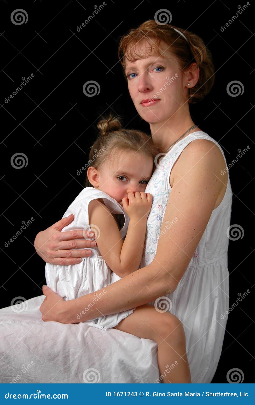 Abrazo de la madre y de la hija. Madre e hija en un abrazo blando sobre un fondo oscuro.