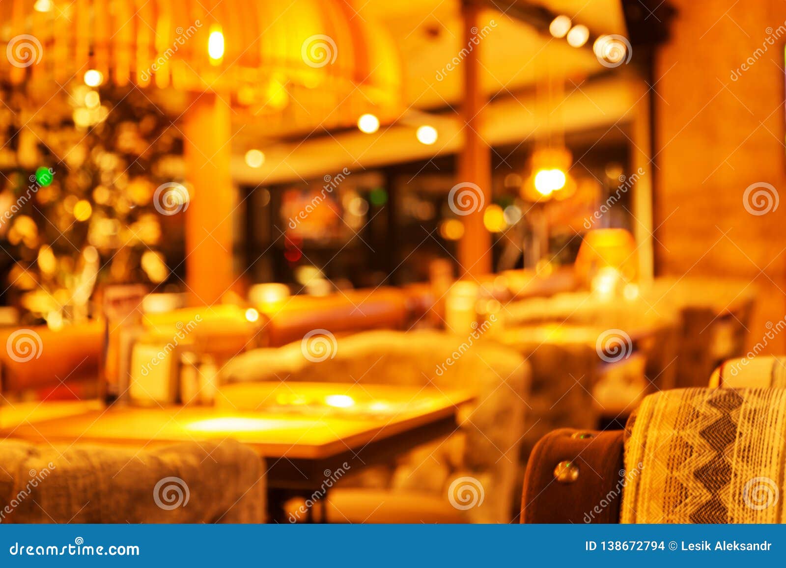 Abstract blurred background of evening cafe, restaurant, pub in warm evening colors. Abstract unsharp background of interior of coffee house, restaurant as blurred background for advertising mounting