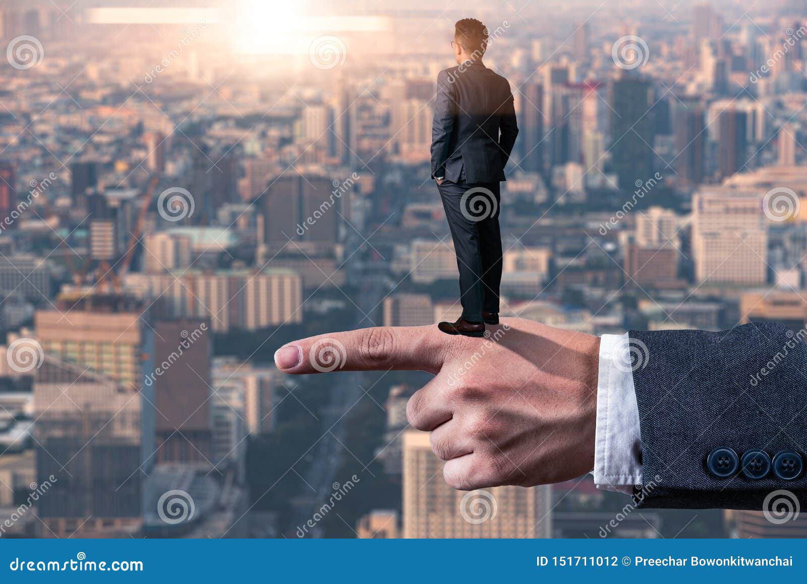the abstract image of the businessman standing back on the finger during sunrise and looking forword. the concept of modern life,