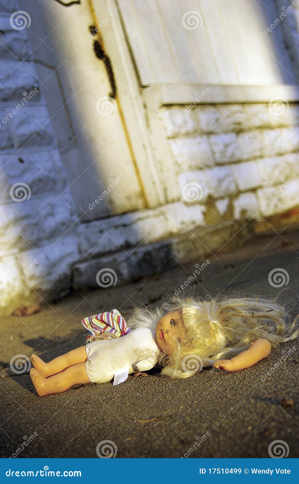 abused doll lying on ground