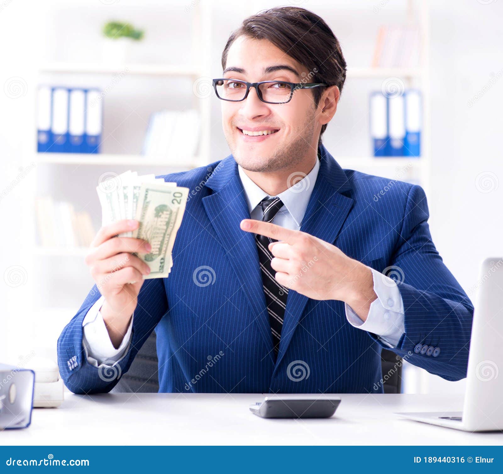 Accountant Calculating Dollars with Calculator in Office Stock Photo