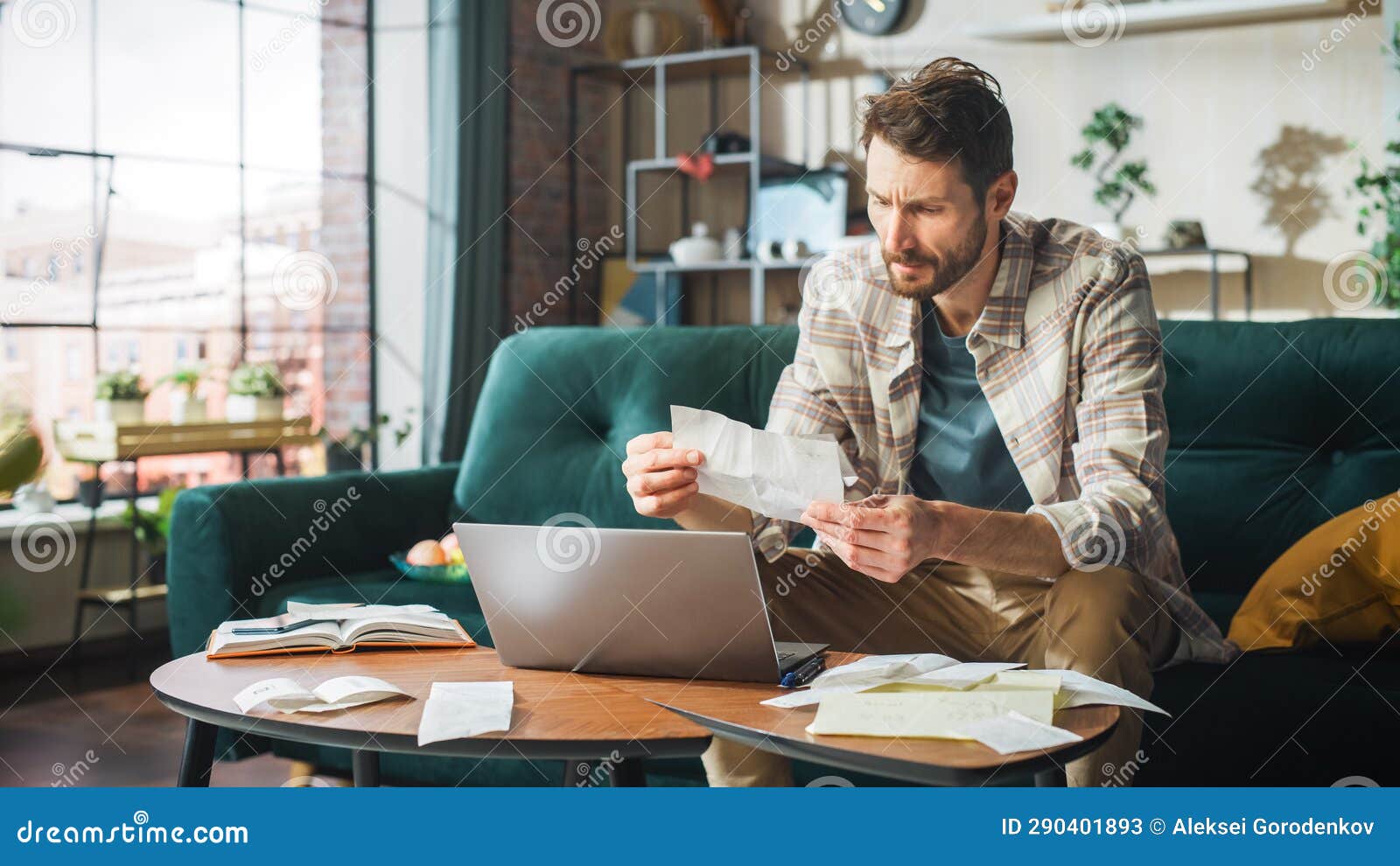 accounting at home: streessed man using laptop computer, filling tax forms. businessman scared of