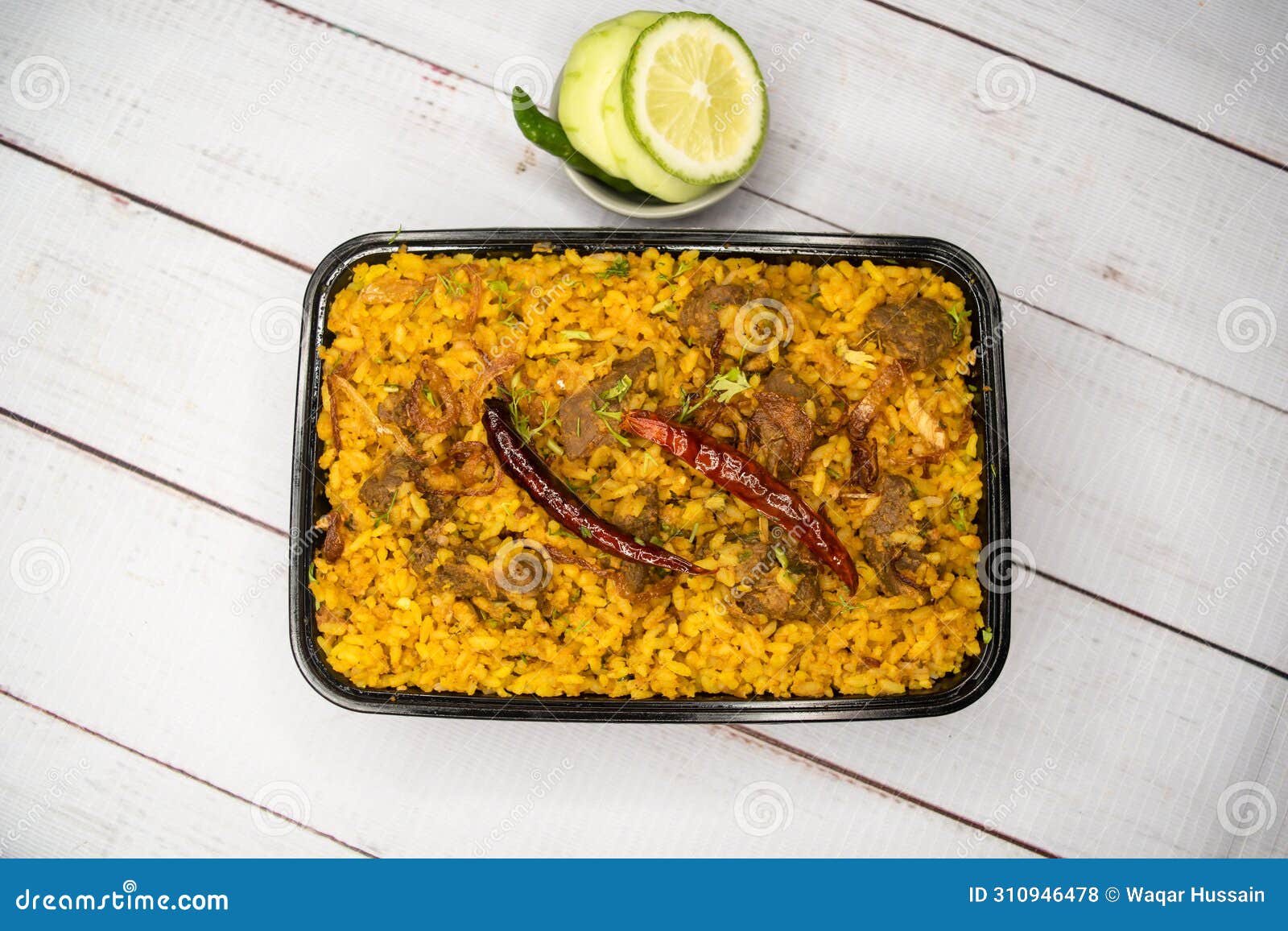 achari beef khichuri biryani rice pulao with cucumber and lemon slice served in dish  on wooden table top view of