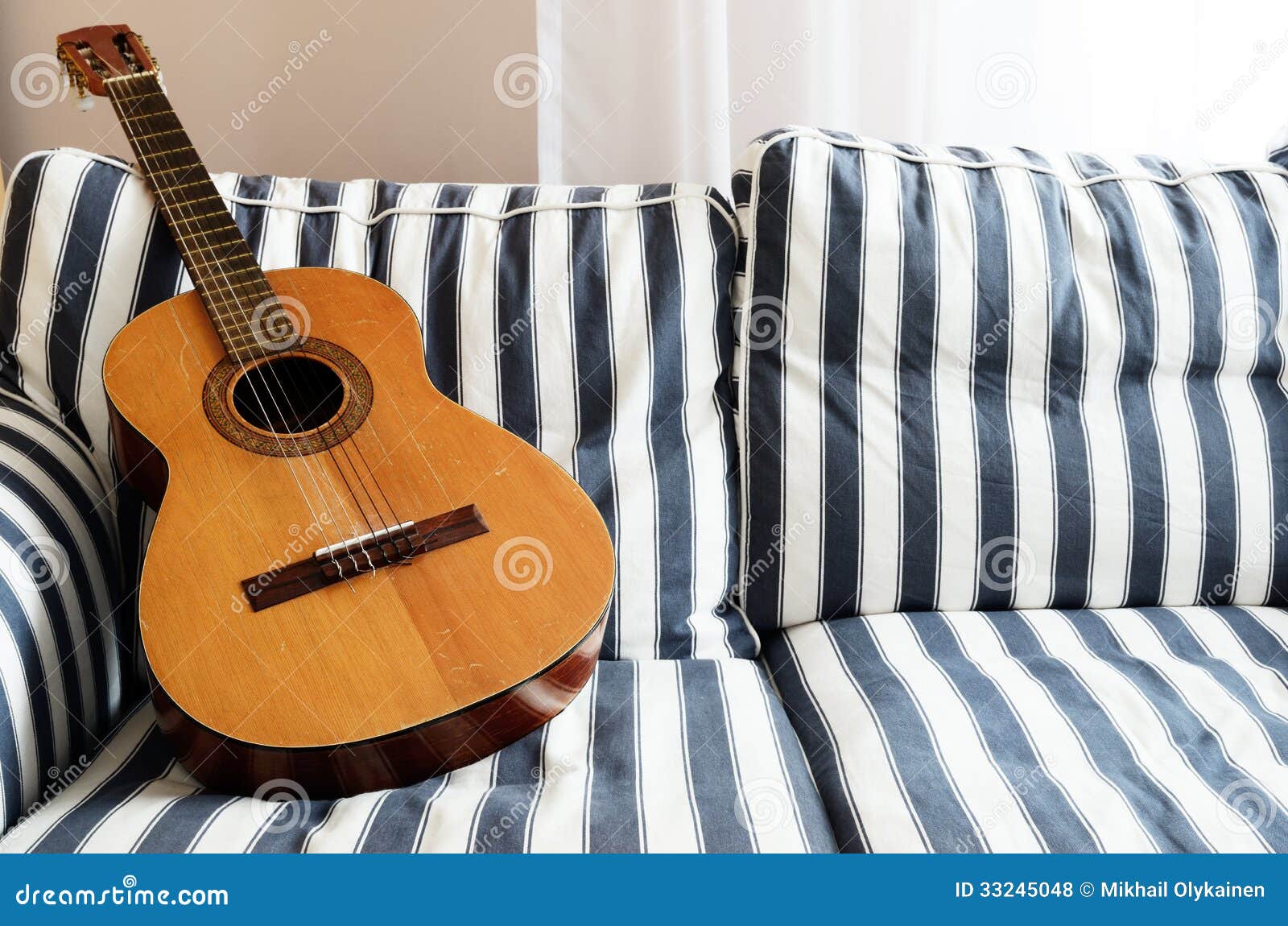 Acoustic guitar on a couch stock photo. Image of performance 33245048