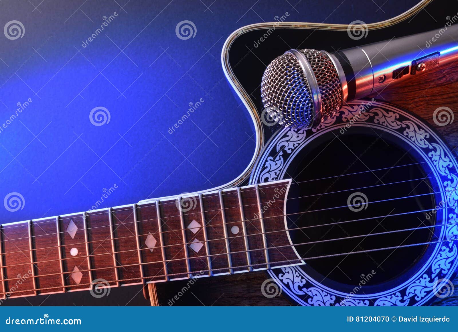 Acoustic Guitar and Microphone Isolated with Red and Blue Lights Stock