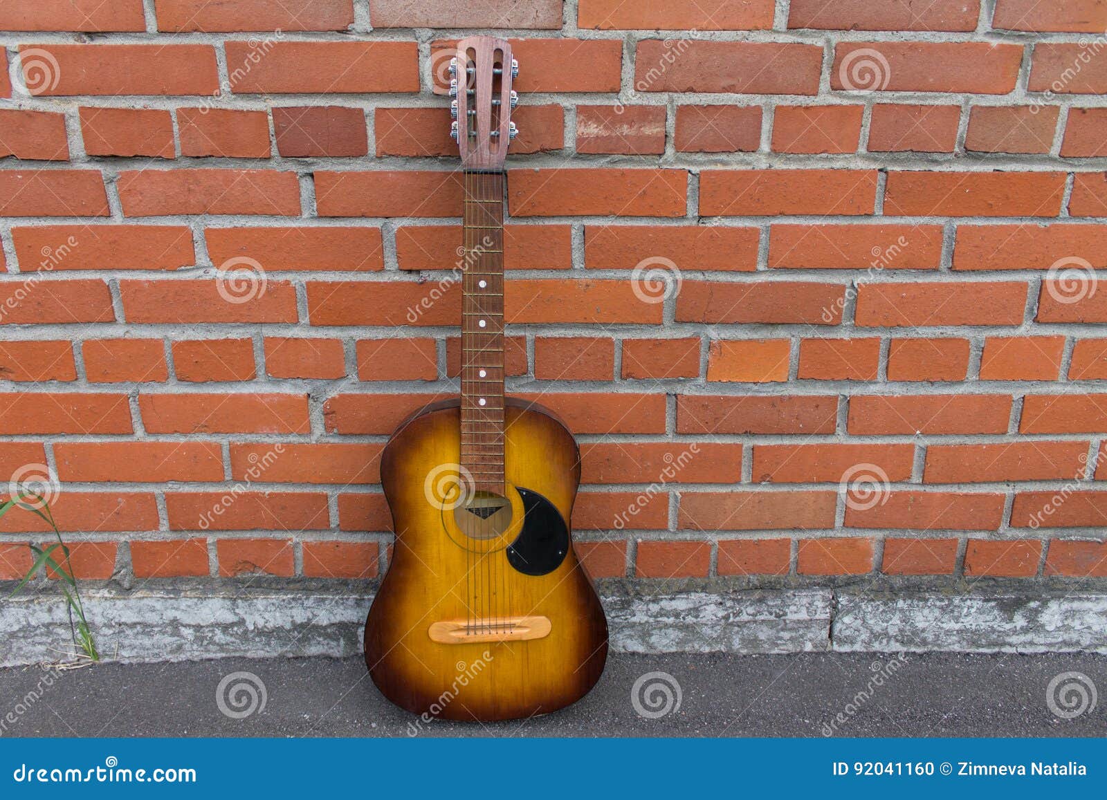 Acoustic Guitar Resting Against a Red Brick Wall Stock Photo - Image of