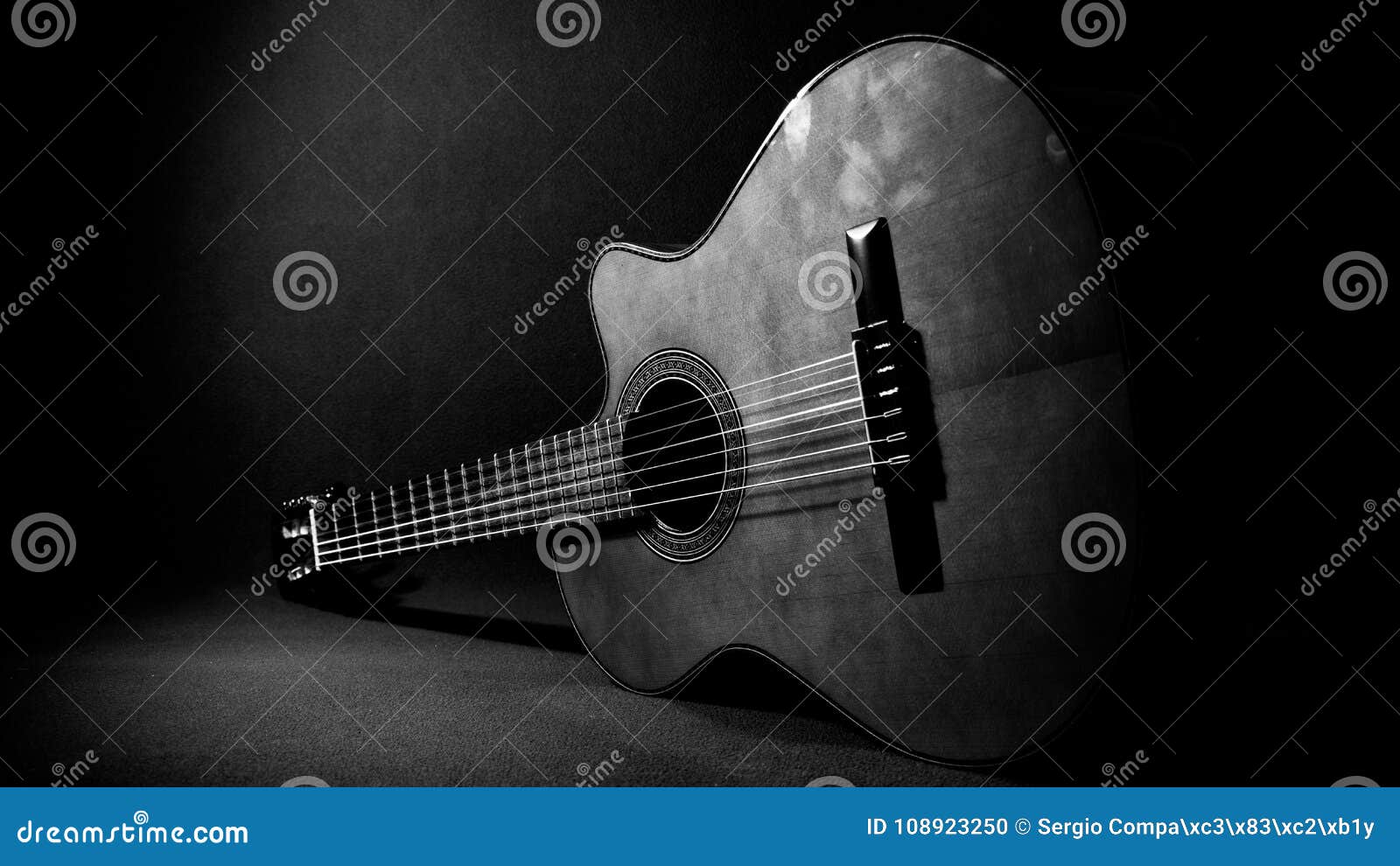acoustic guitar resting on the floor