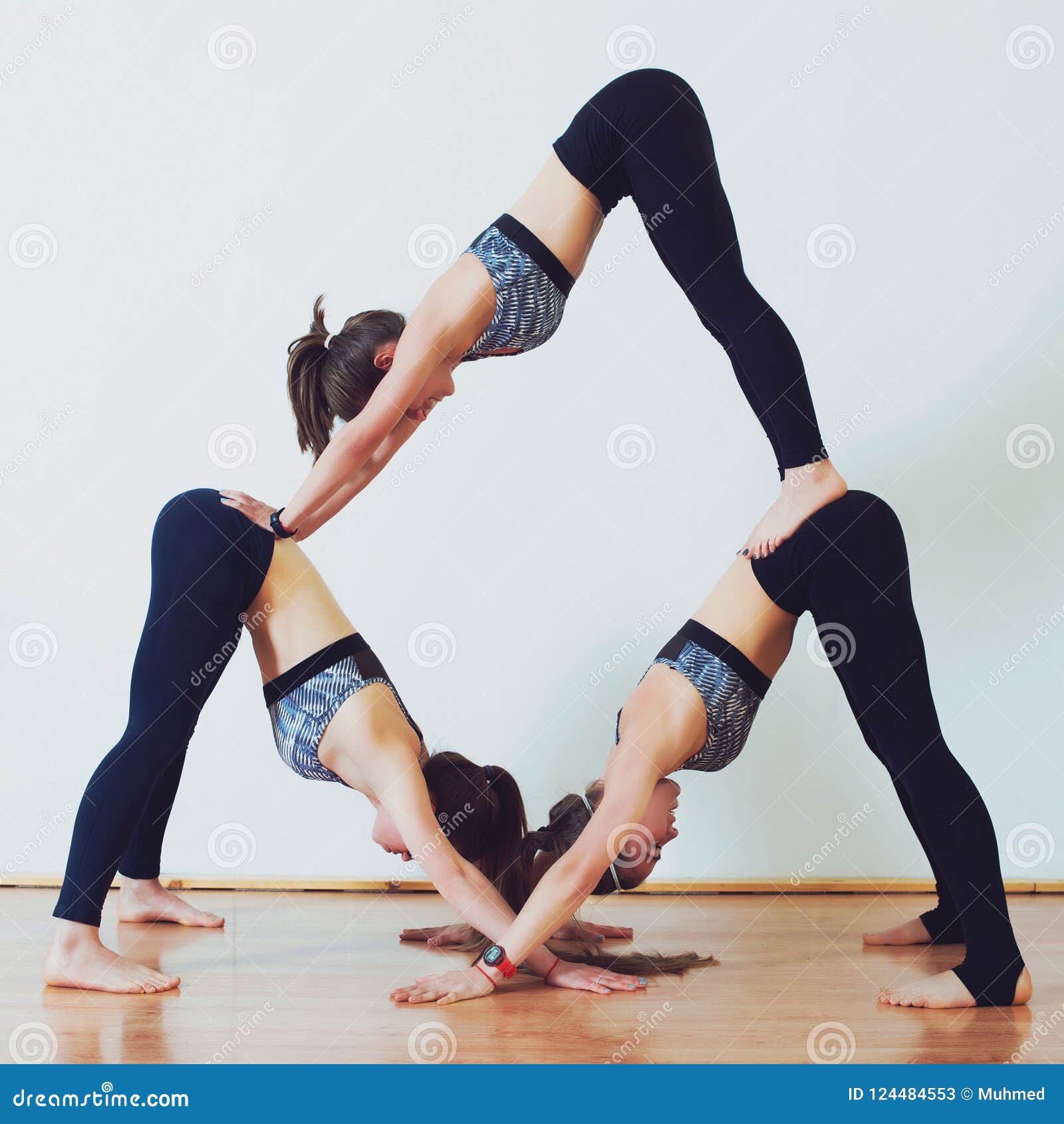 Acro Yoga, Three Sporty Girls Practice Yoga in Pair. Partner Yoga