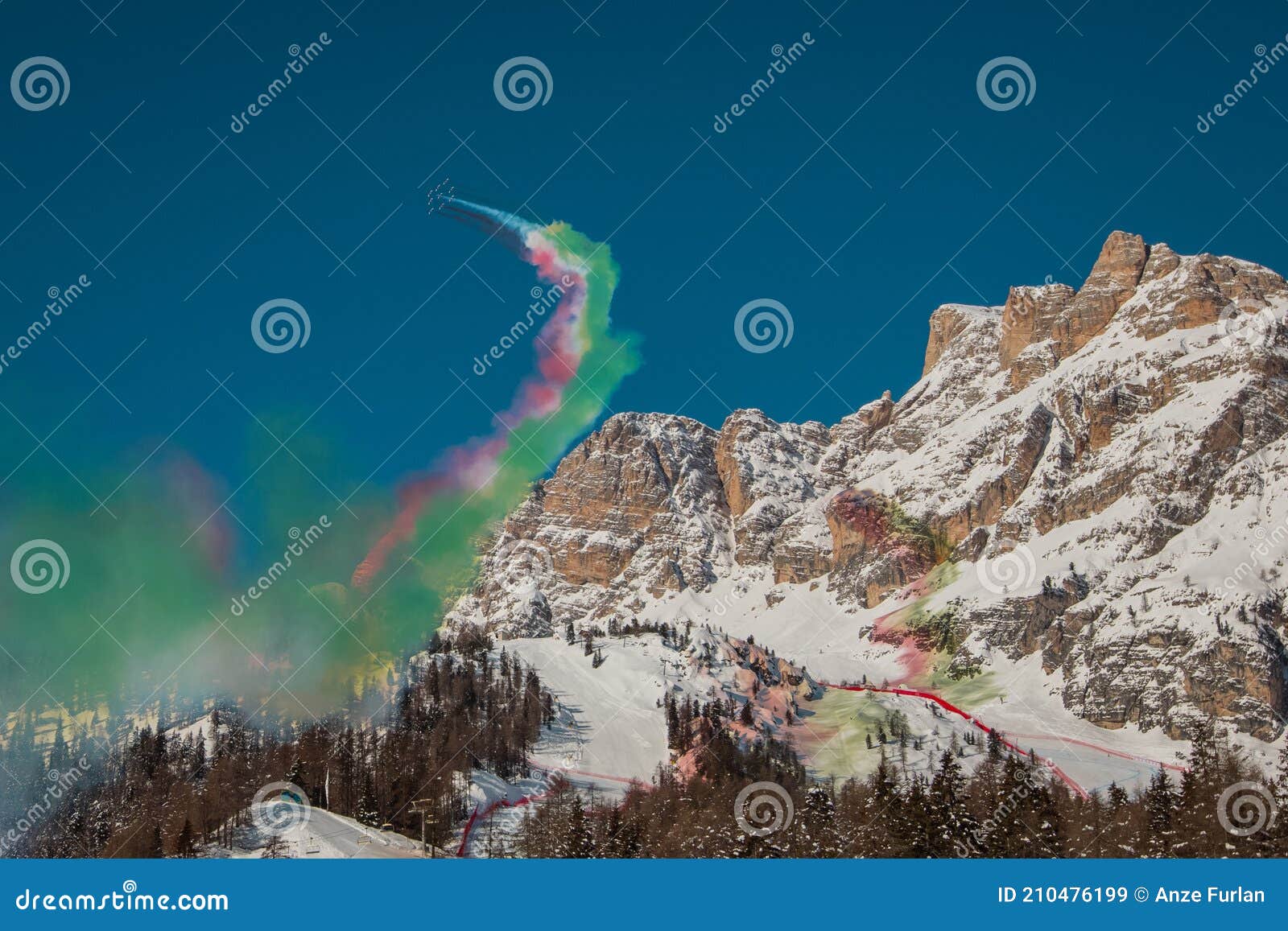 acrobatic group of freccia trecolori jet aeroplanes are performing maneouvres in a formation in the italian dolomites close to