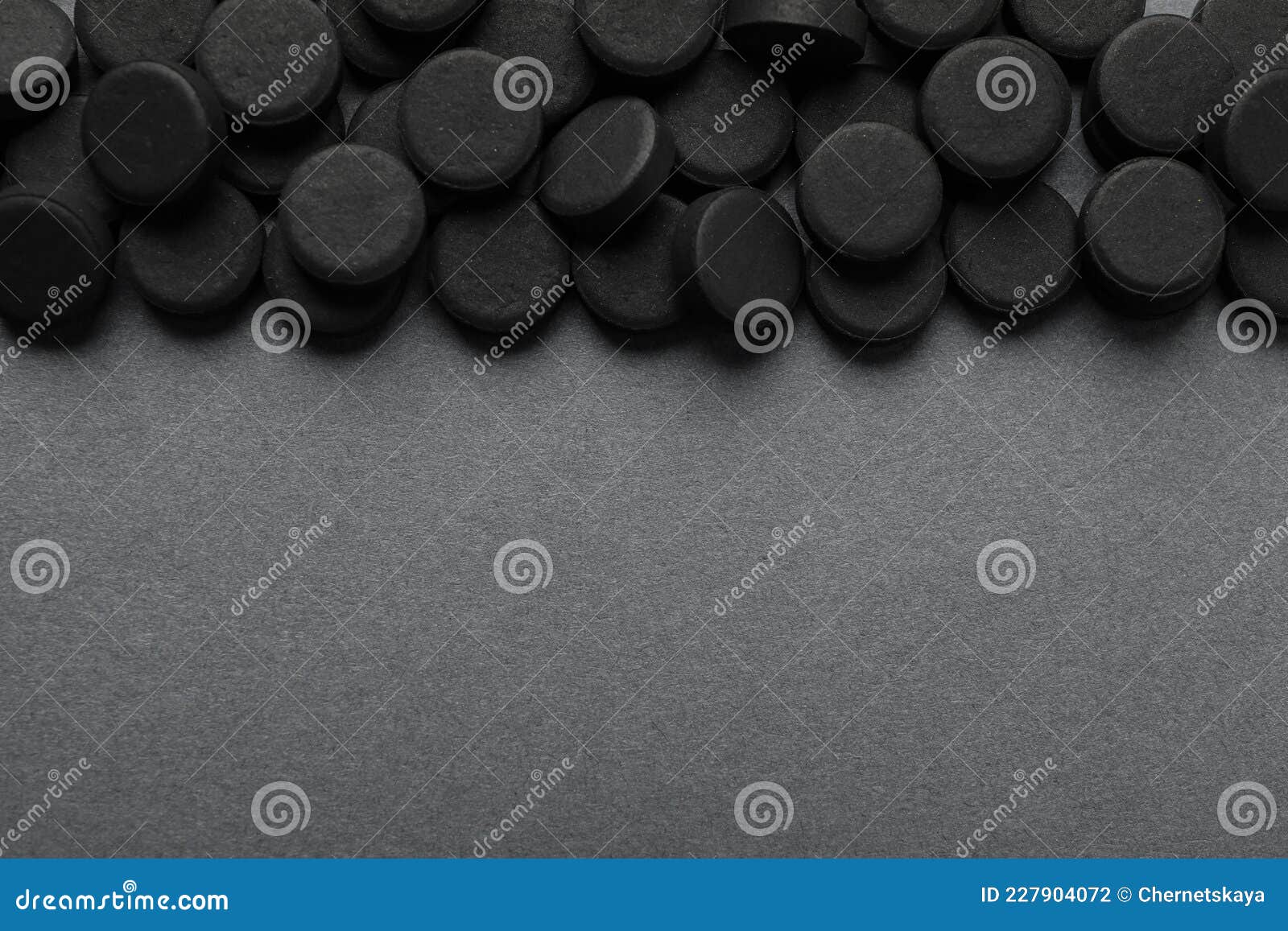 activated charcoal pills on grey background, flat lay with space for text. potent sorbent