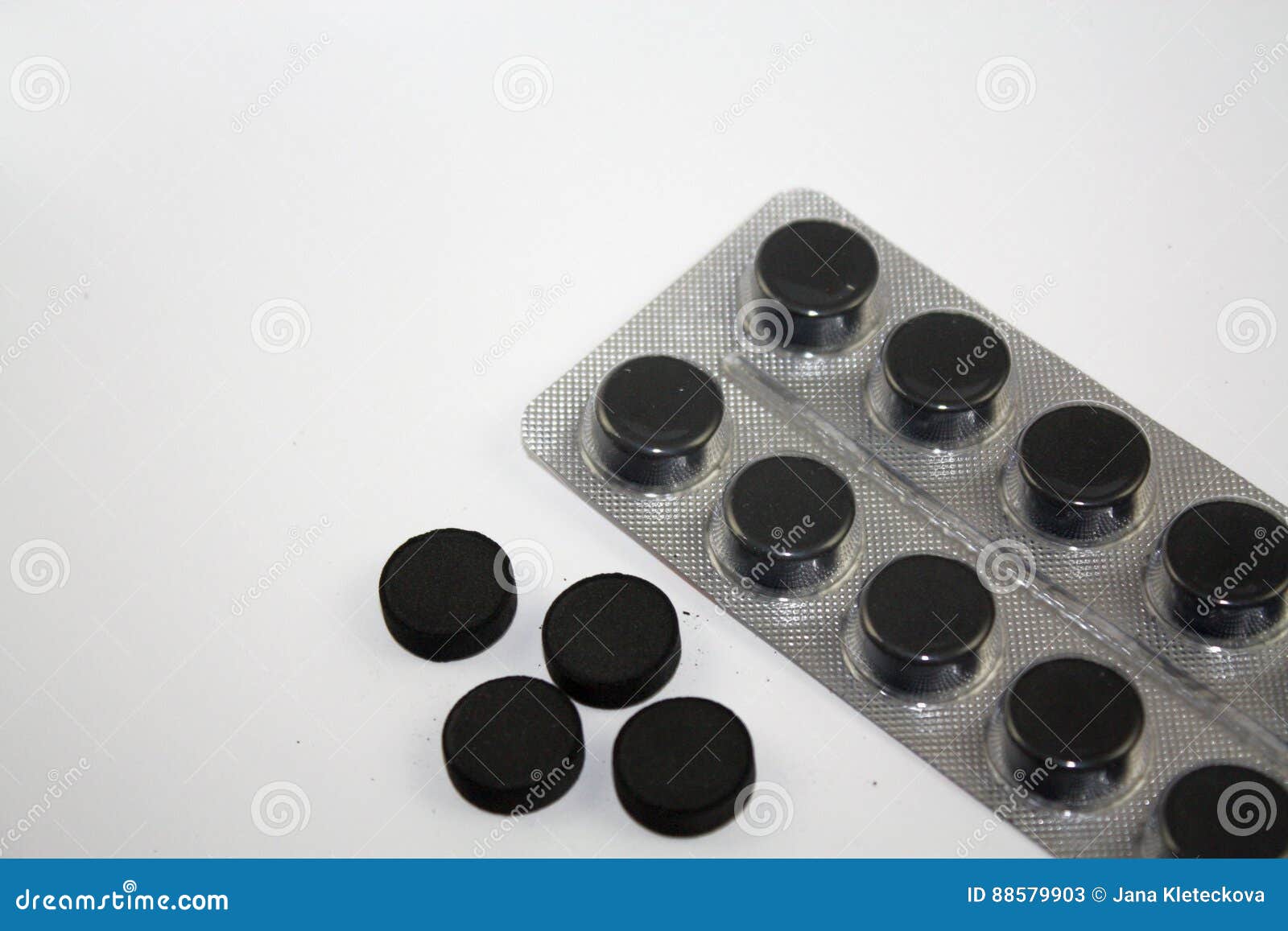 Activated Charcoal Round Black Tablets Pills and Blister on White