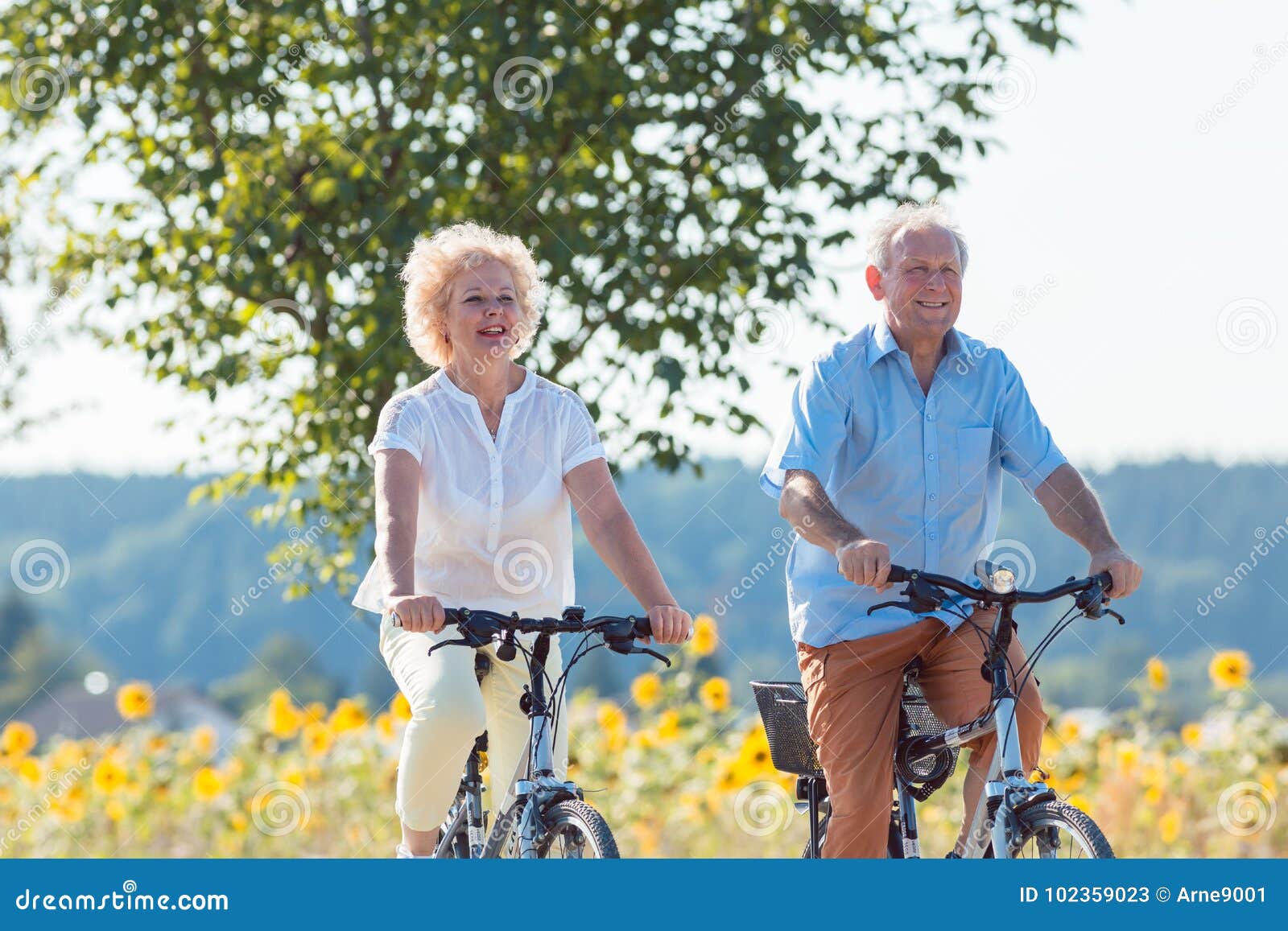 active elderly couple riding bicycles together in the countrysid