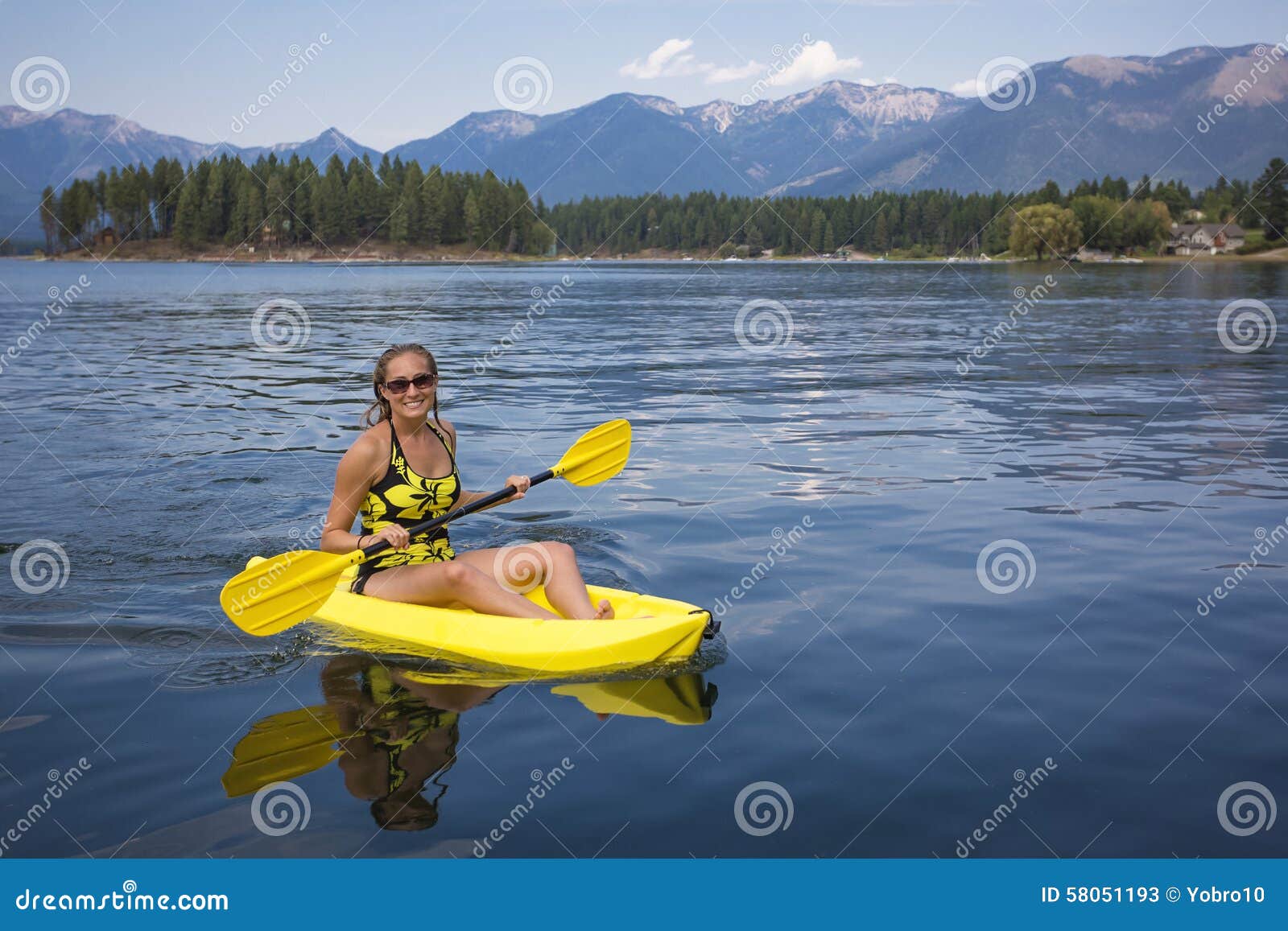 Active, Fit Woman Kayaking On A Beautiful Mountain Lake 