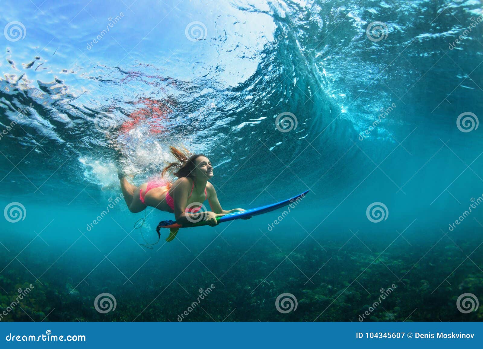 active girl in bikini in dive action on surf board