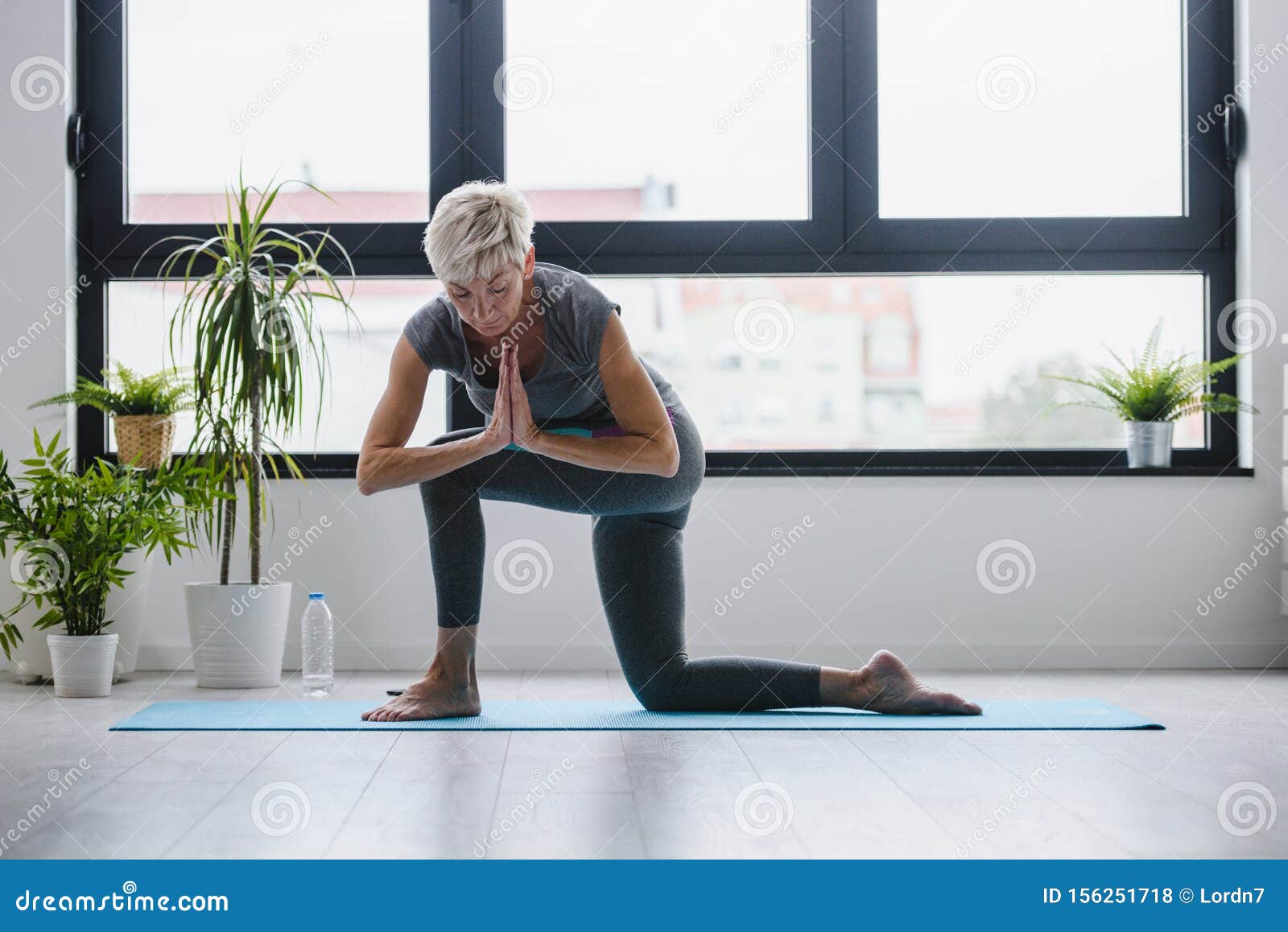 active senior woman practicing yoga indoors