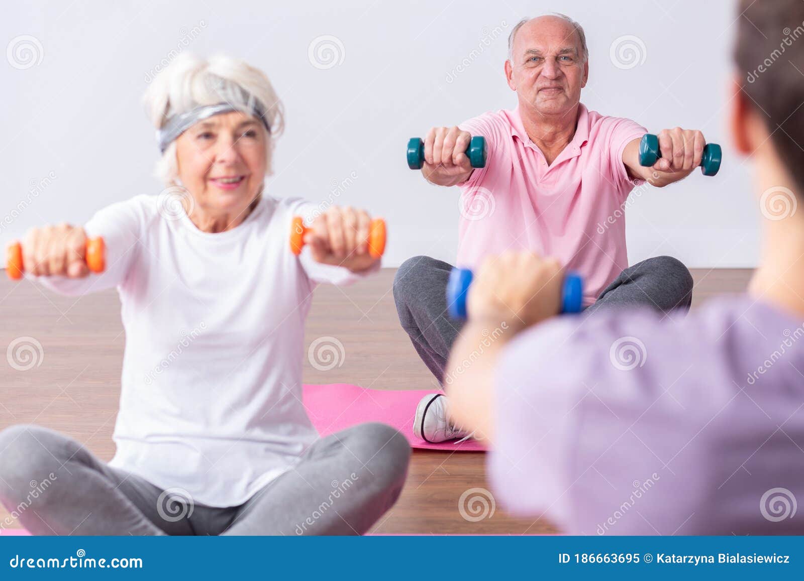 active seniors during exercises on gym with young instructor