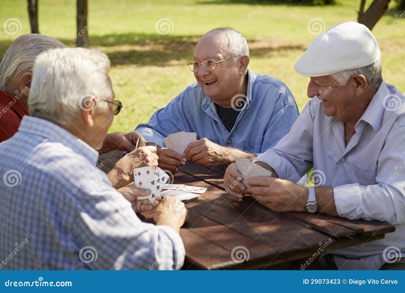 active seniors, group of old friends playing cards at park